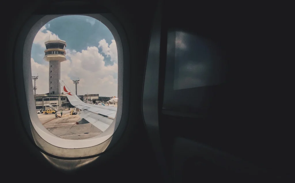 A picture of a airplane window looking out to see the tower in the distance, representing in this case a tower server which unlike blade or rack servers is typically an isolated vertical configuration.